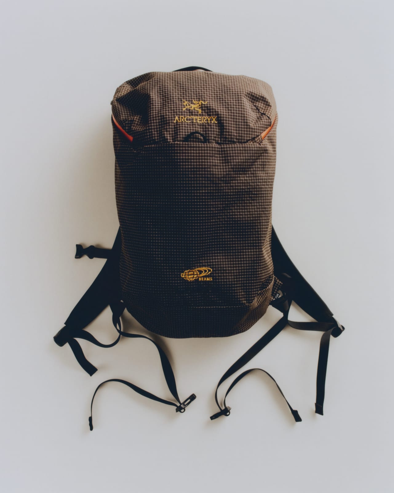 The ARC'TERYX x BEAMS Konseal 15 backpack in brown grid fabric with gold logos