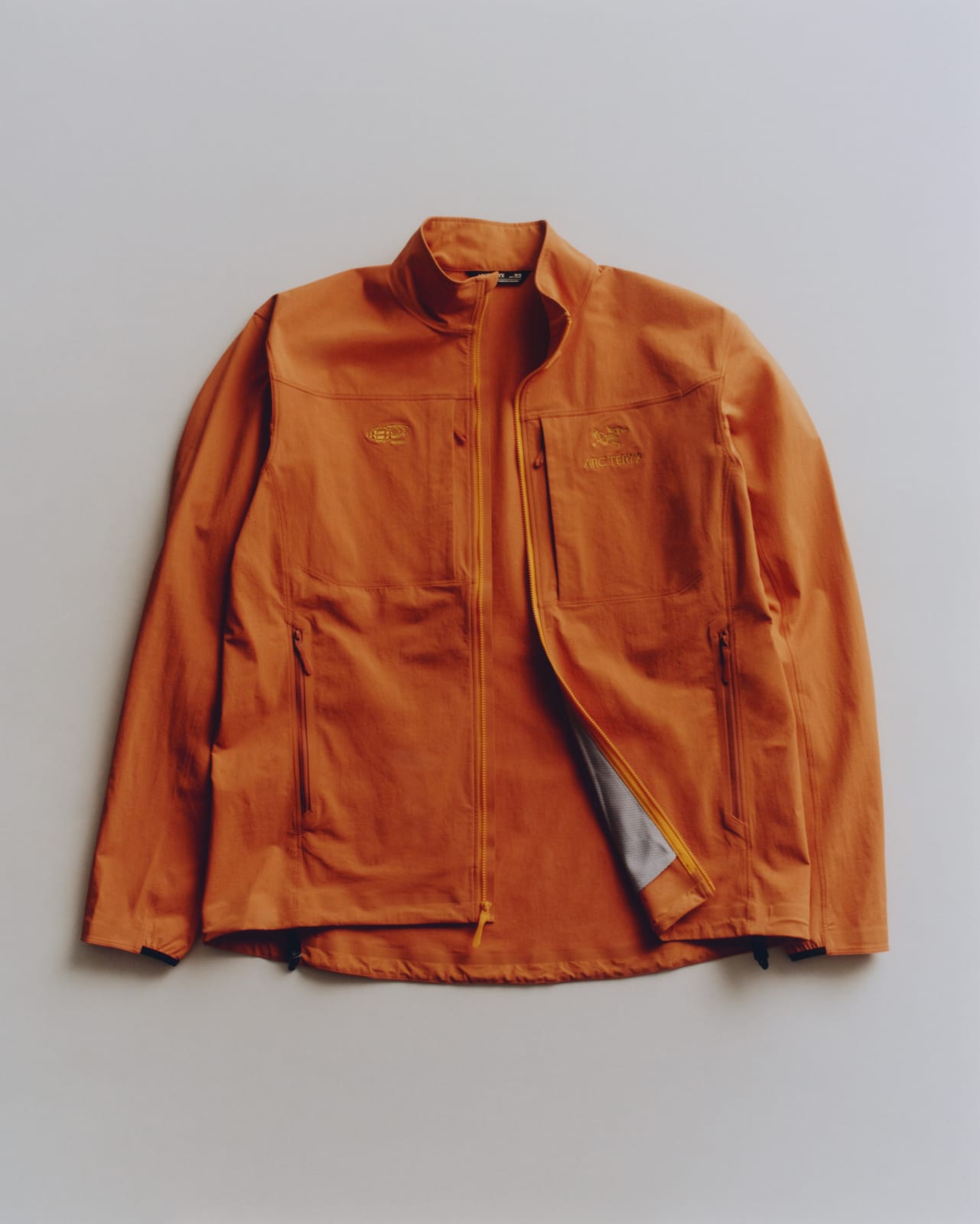 The ARC'TERYX x BEAMS Gamma softshell jacket in BEAMS orange, laid flat