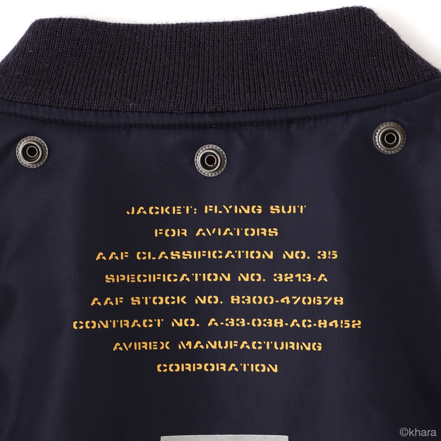 Close-up of the navy Mark.06 jacket's upper back, with an orange stenciled flying-suit specification below the collar