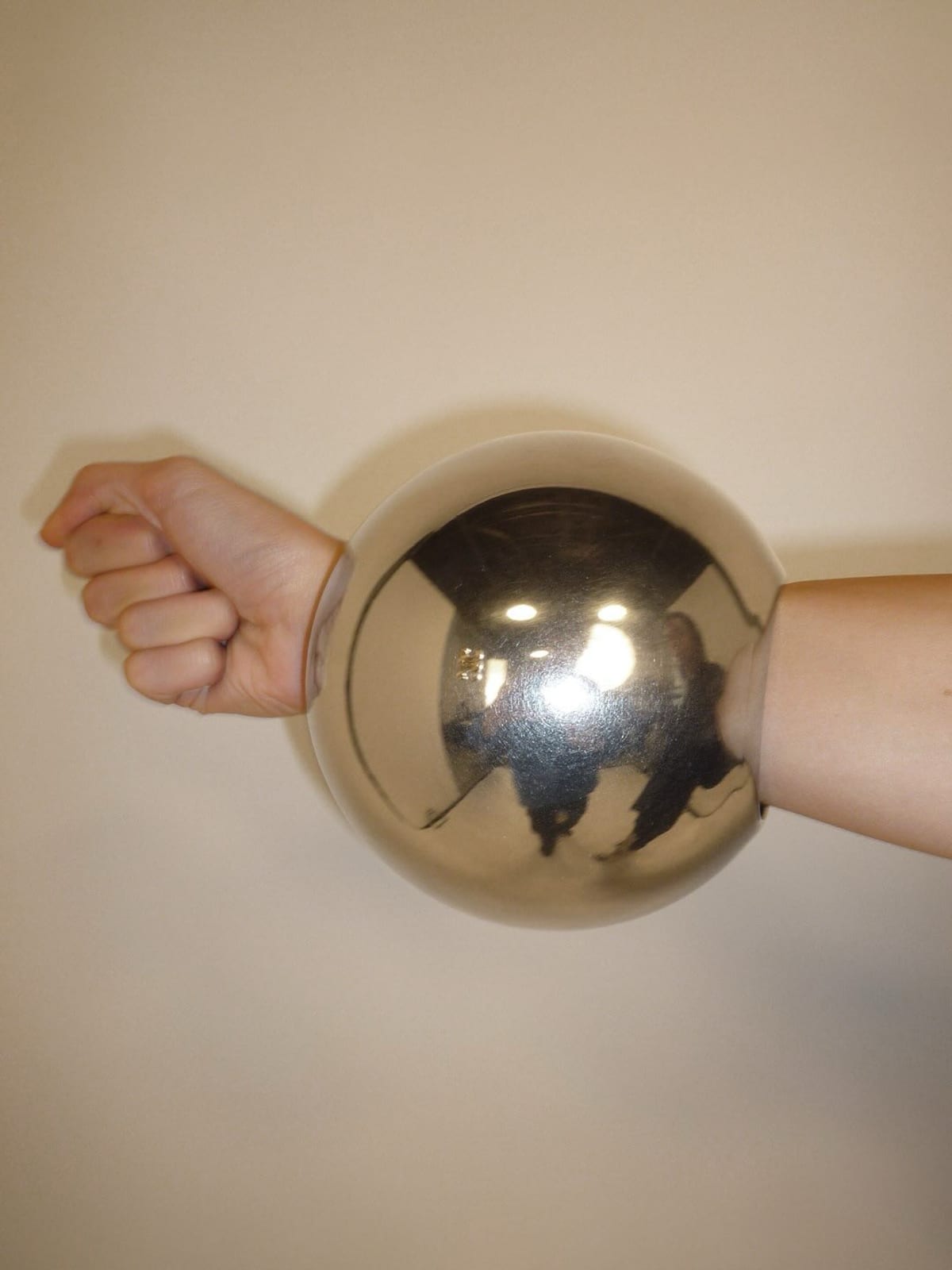 A large, mirrored silver ball-shaped bangle on a wrist, from Celine's Spring 2027 show