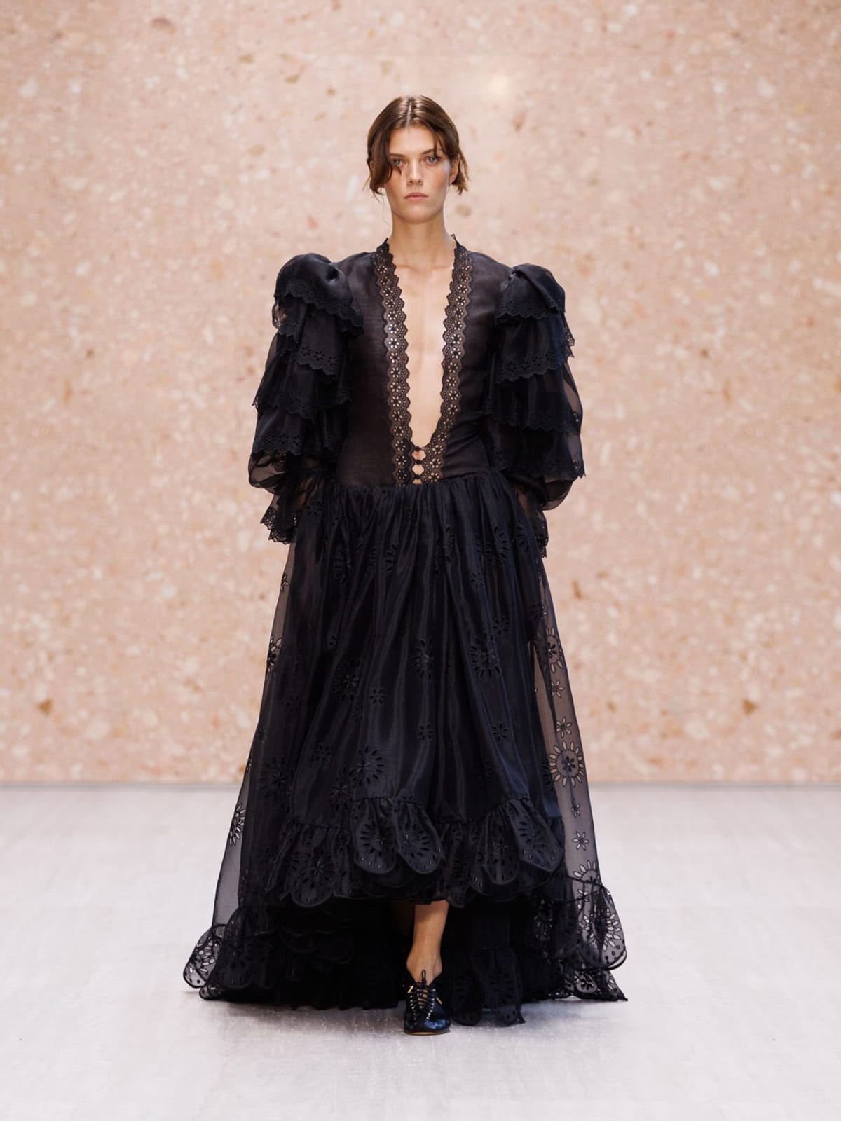 A Chloé Spring/Summer 2027 look: a black tulle dress with a deep plunging neckline, ruffled puff sleeves and a high-low hem