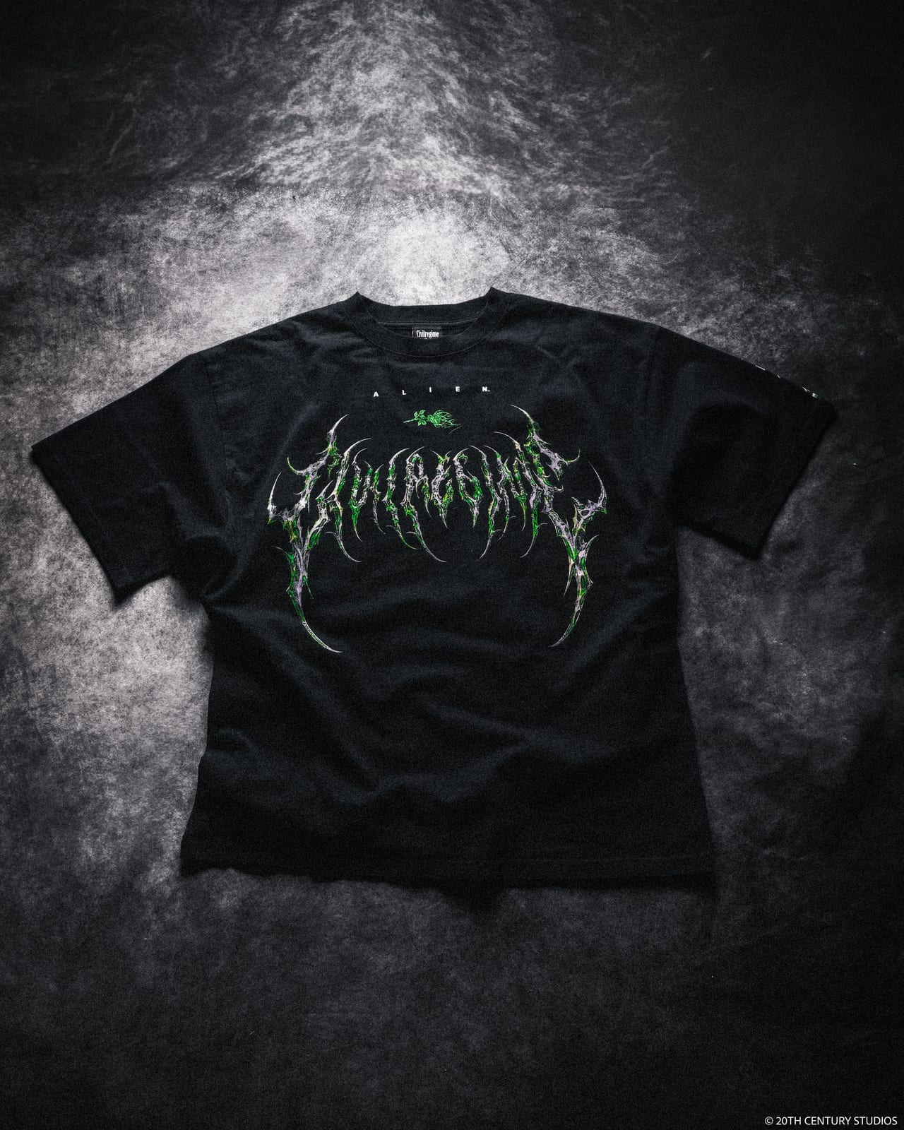 A black Civil Regime tee with the brand's name in a jagged green and silver metal-style logo across the chest, under a small ALIEN wordmark and a green rose