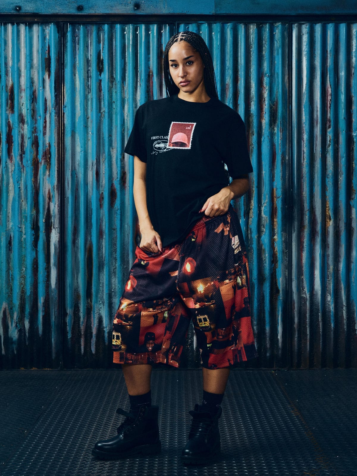 A model in Corteiz's black Konnichiwa 10th Anniversary tee and 'It Ain't Safe' mesh shorts, from the Konnichiwa anniversary collection