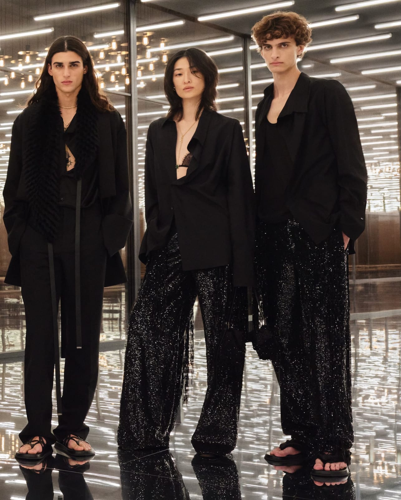 Three Fendi Spring 2027 looks in black: open tailored jackets over bare chests and bra tops, with sequinned trousers and flat sandals