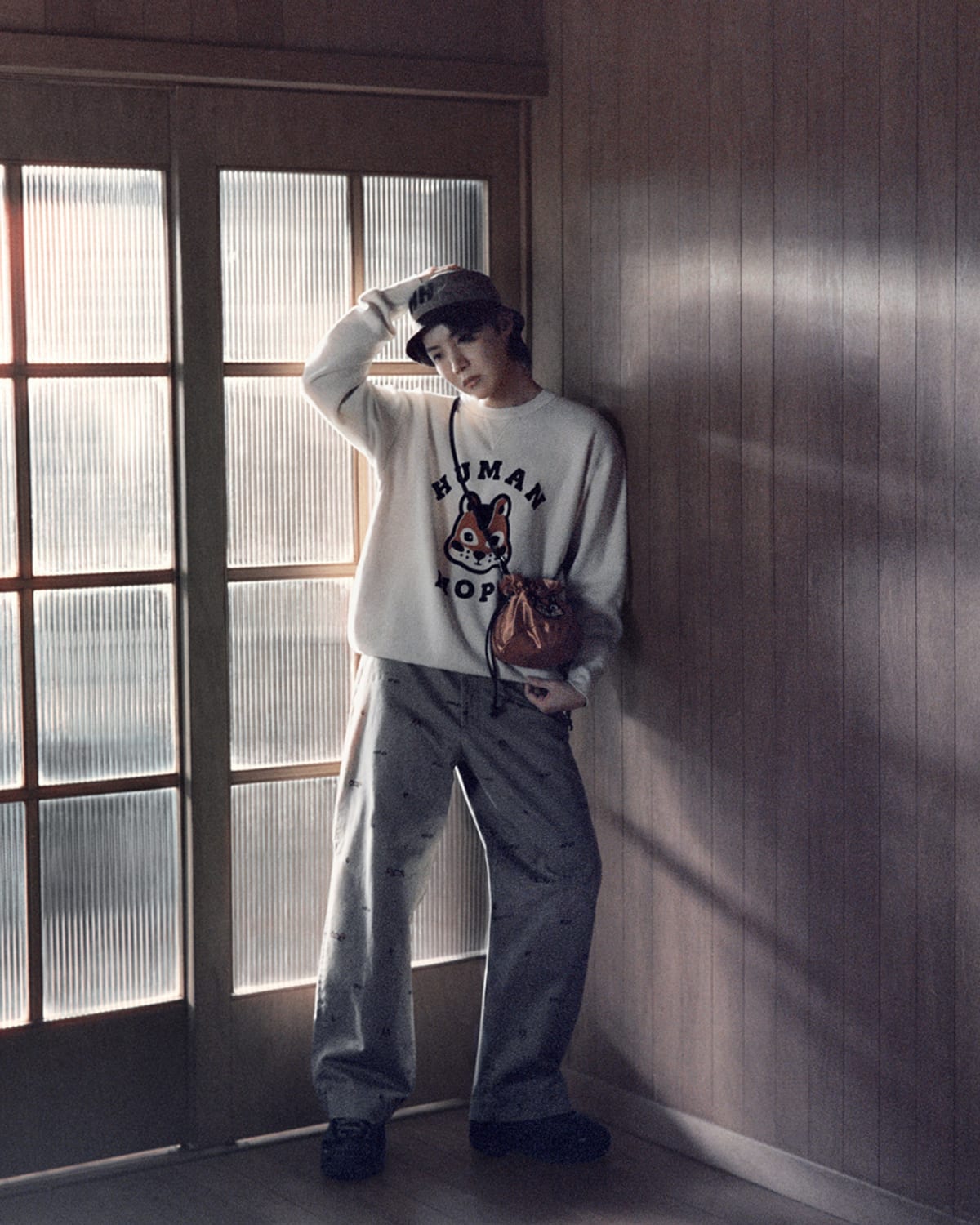 From HUMAN MADE's HUMAN HOPE Season 2 campaign: a white sweatshirt with the squirrel graphic and HUMAN HOPE lettering, worn with printed grey trousers, a cap and a brown pouch