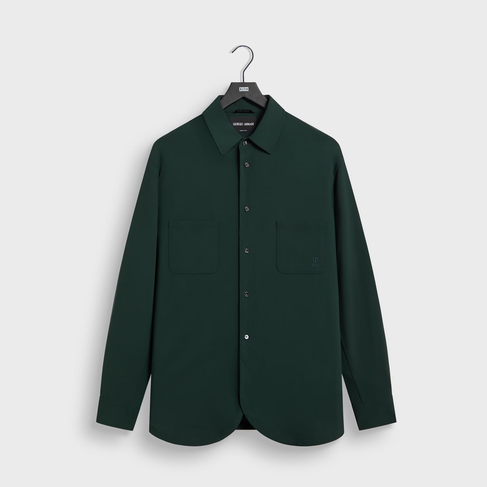 The Giorgio Armani & Kith Ivy wool crepe shirt in Stadium green, with two chest pockets, a rounded hem and a small embroidered Armani and Ivy mark on the right pocket, on a Kith hanger
