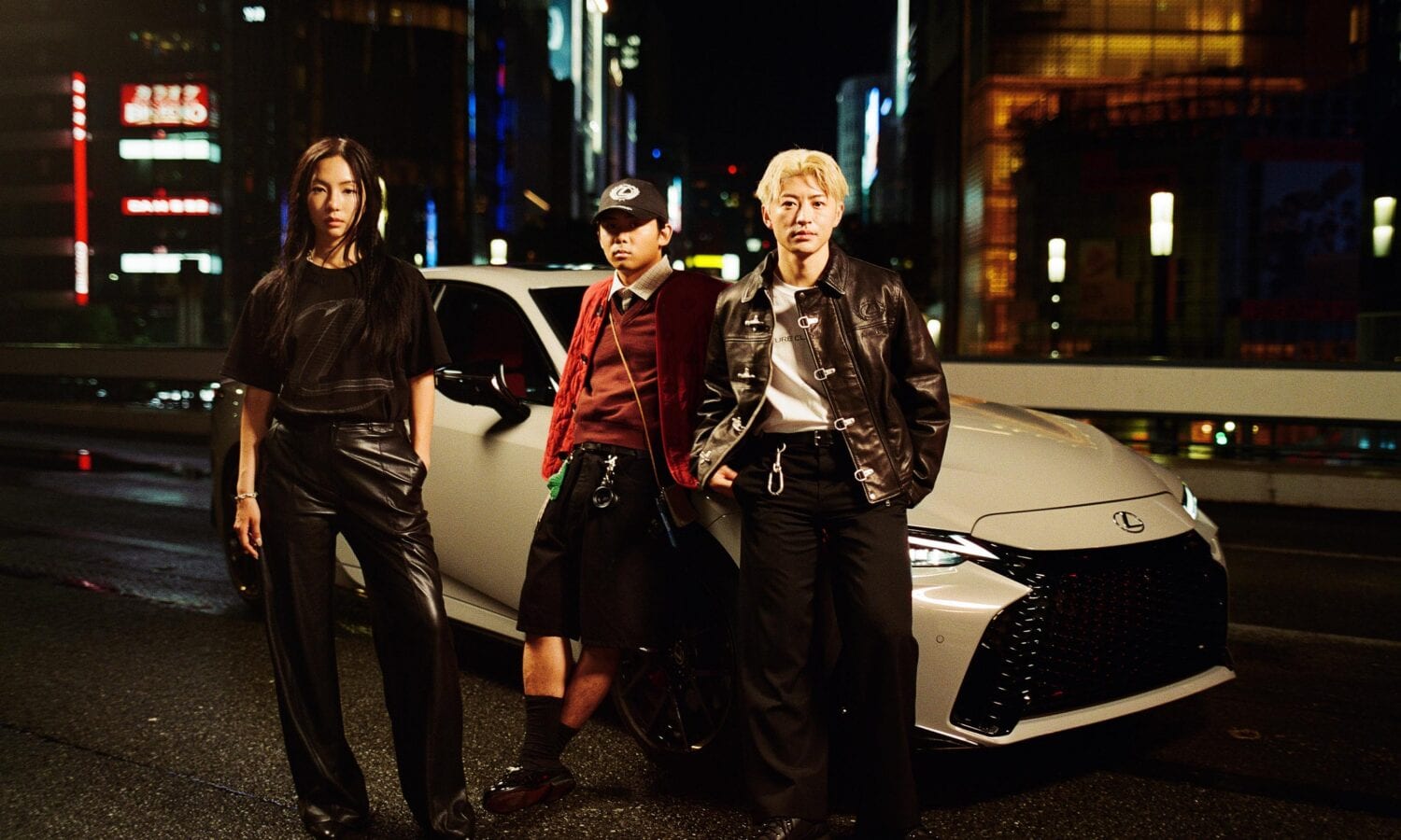 Sara Choi, Reo Sano and Reiji Okamoto standing beside a white Lexus IS on a lit Tokyo street at night, in the Future Classic Club capsule