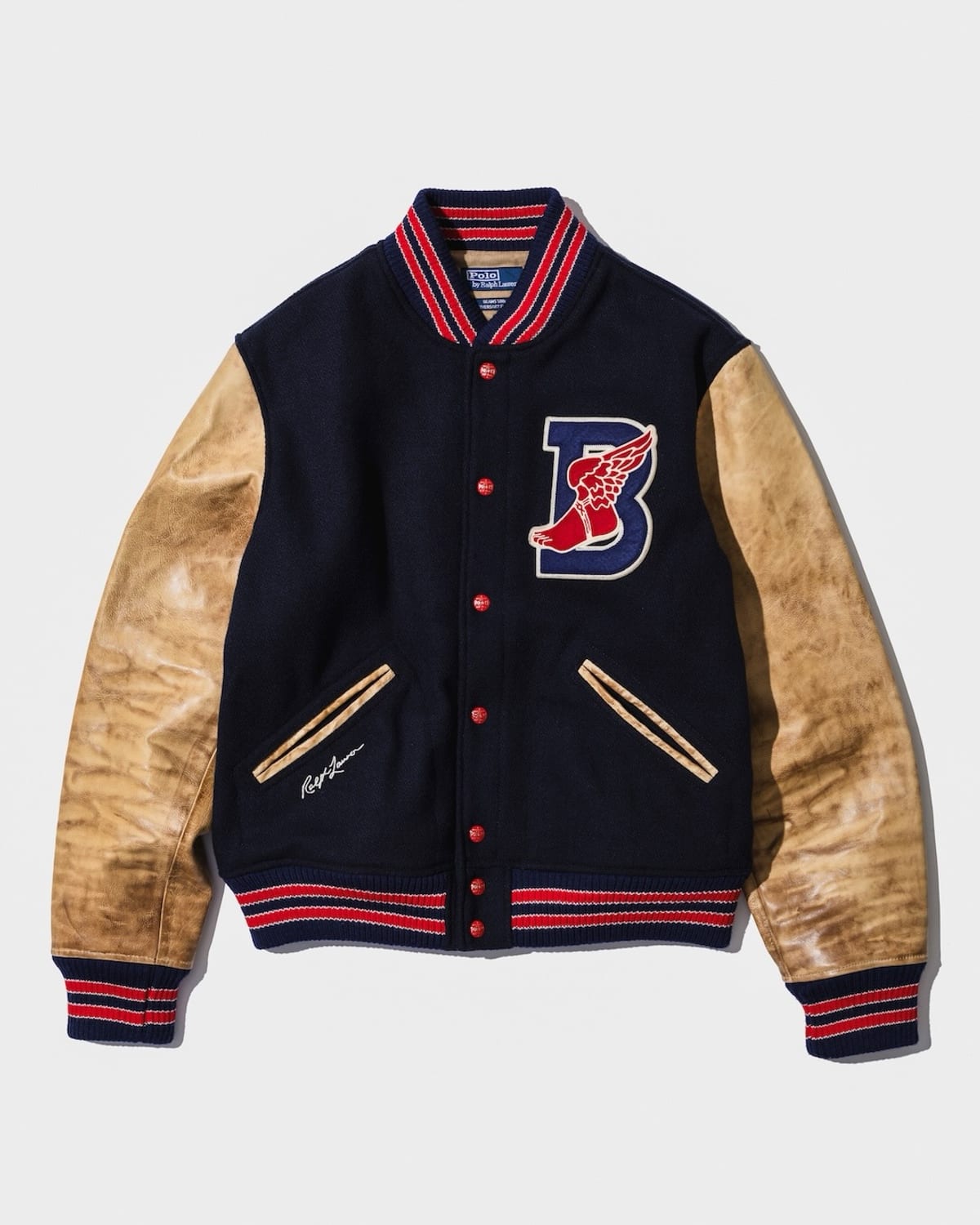 The Polo Ralph Lauren for BEAMS B-WING letterman jacket in navy with tan sleeves, striped trim and a B-WING patch on the chest