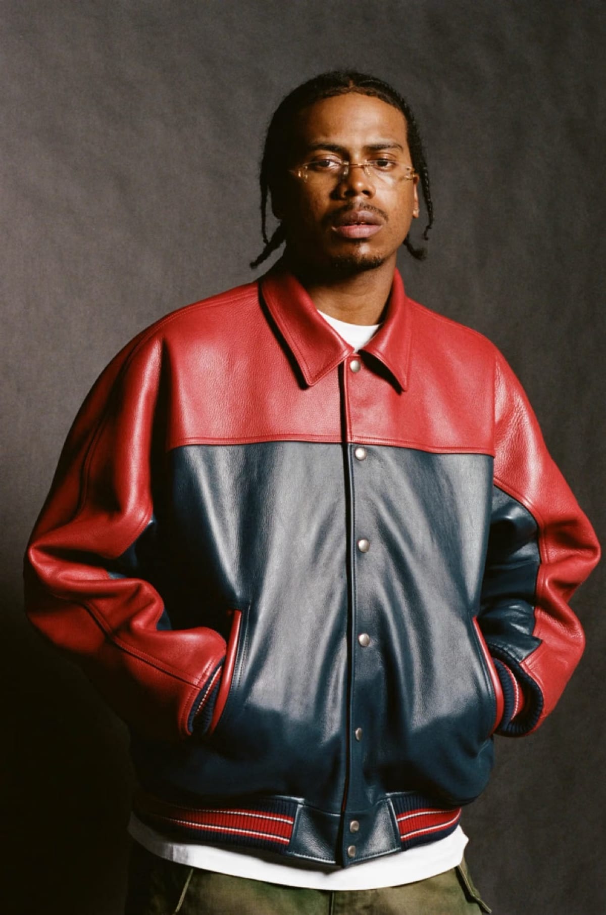 A model in the red and navy cowhide leather jacket from Supreme x A.PRESSE