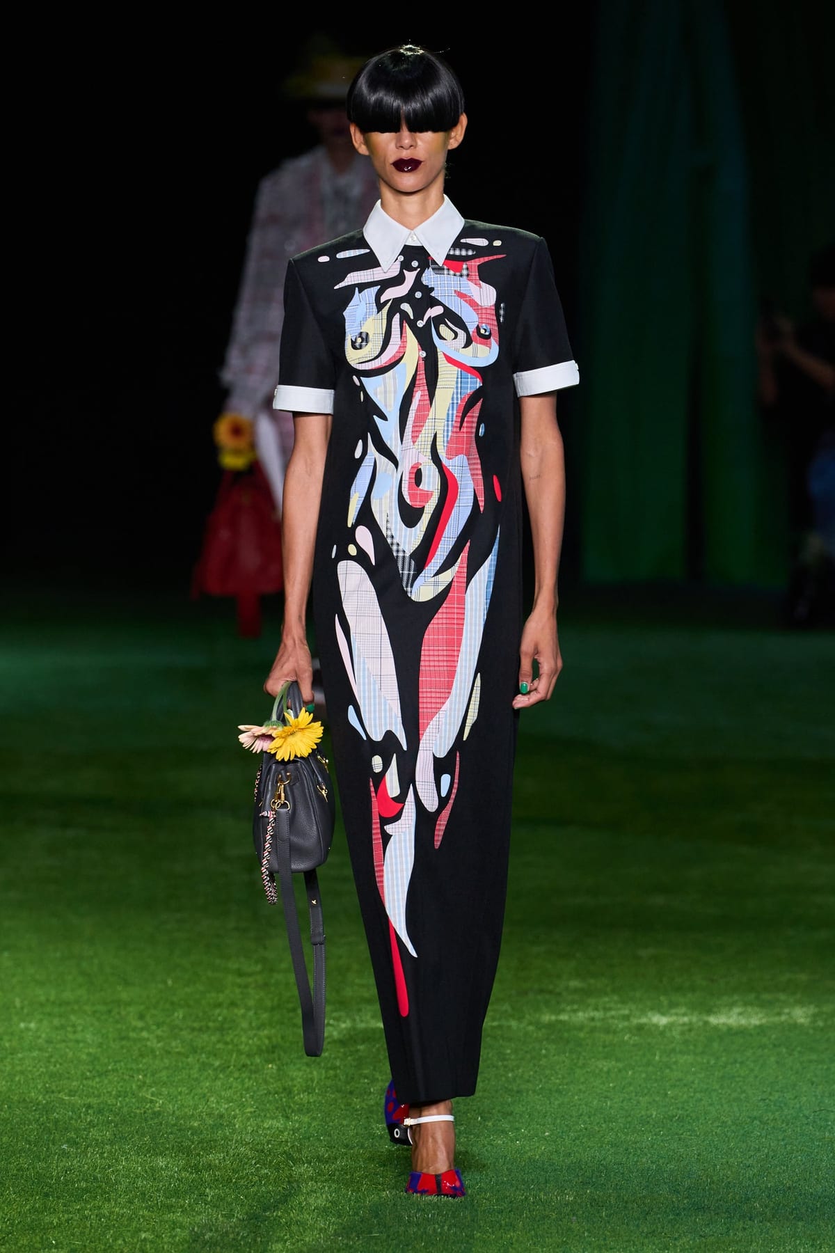 A black shift dress from Thom Browne's Spring 2027 collection with an abstract butterfly print in pale plaid, sky blue and red across the bodice and skirt, worn with a white point collar