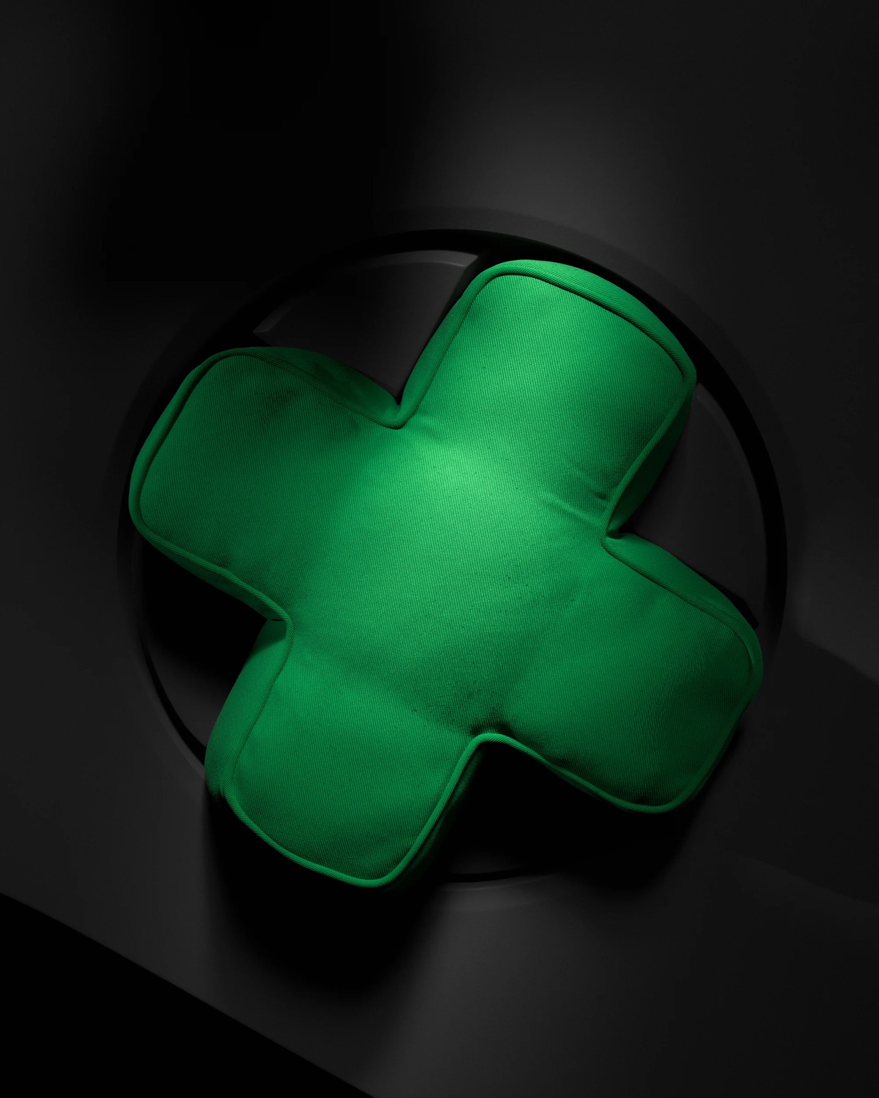 The green Xbox D-pad cushion from the IKEA collaboration, shot against a dark controller-face backdrop